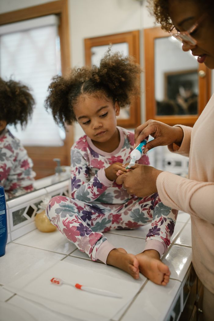 The Art of Drawing Readers In: Your attractive post title goes here A mother assists her daughter with brushing teeth during a morning routine, fostering hygiene habits.
