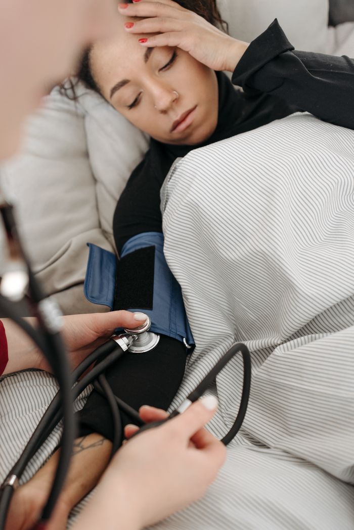 Services A patient getting her blood pressure checked while resting at home.