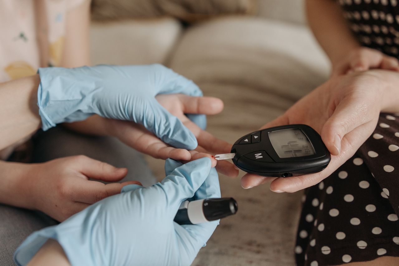 Services Hands measuring blood glucose levels with a glucose meter and test strip.